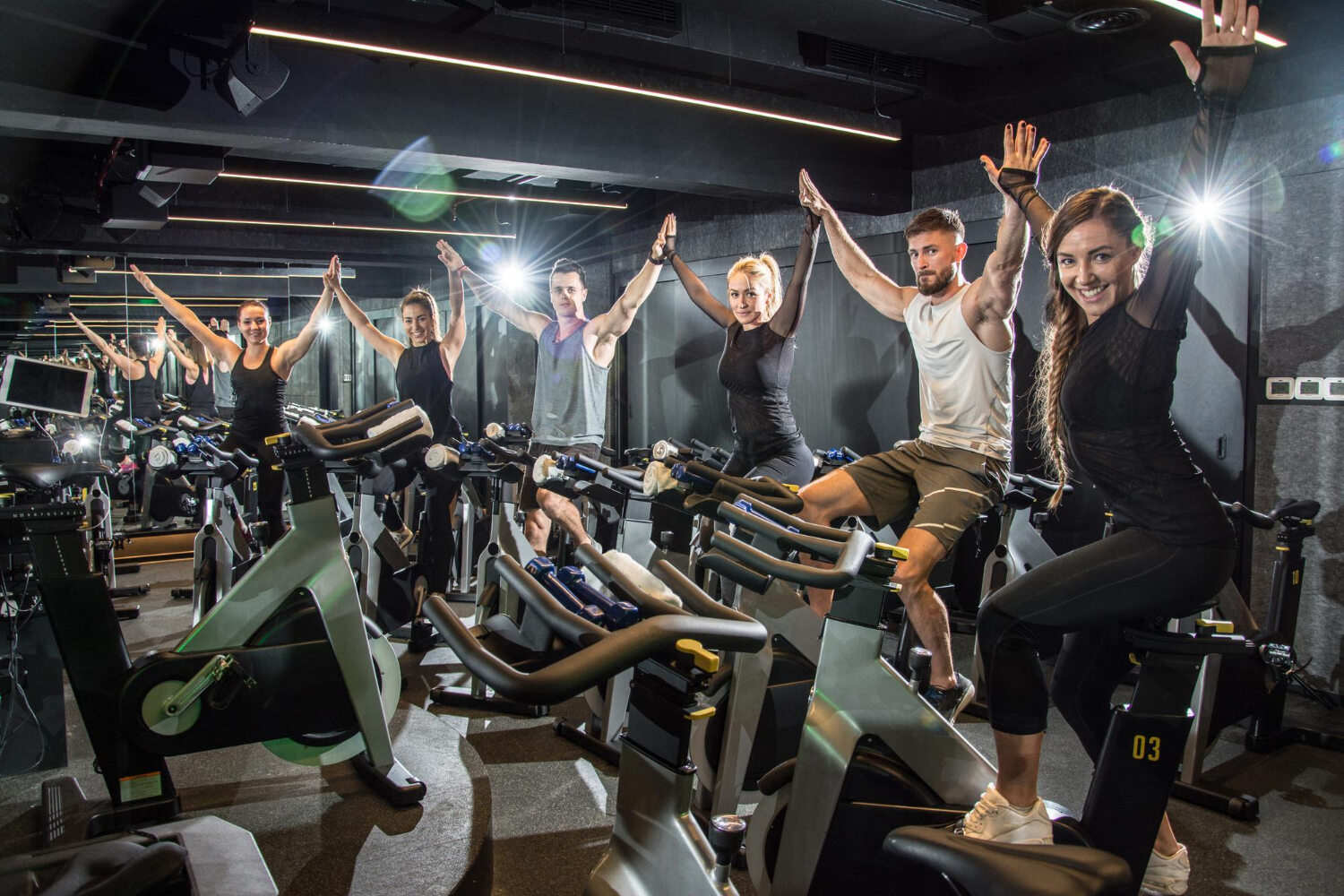 Group of people enjoying a spin class workout with motivational lighting and music