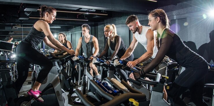Group of people enjoying a spin class workout with motivational lighting and music